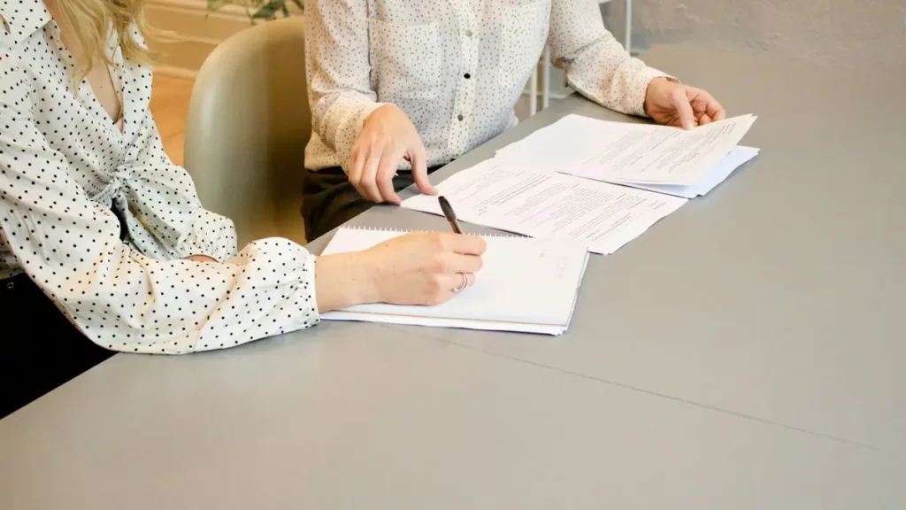 Deux collègues qui remplissent des documents sur un bureau