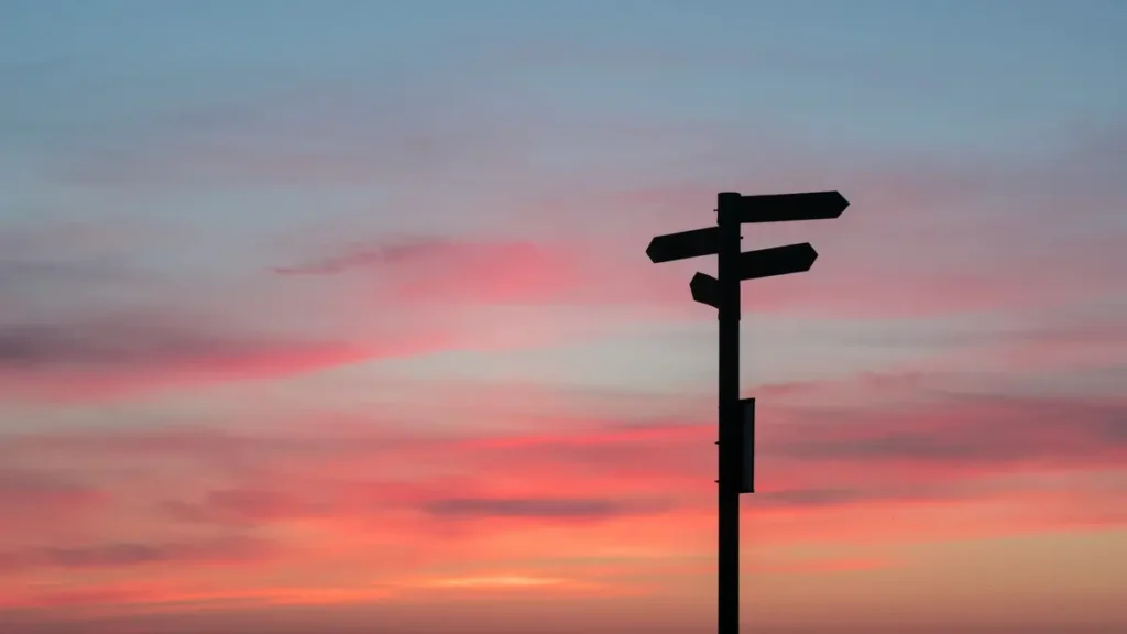Panneau indicateur à un carrefour au coucher du soleil