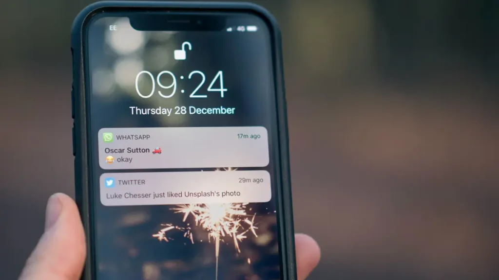 Main qui tient un smartphone affichant des notifications