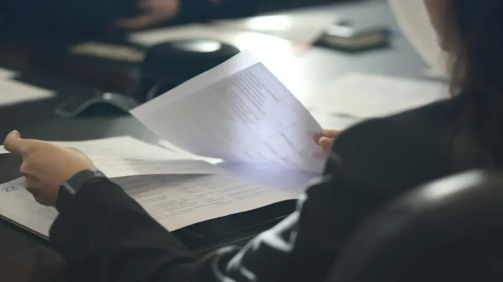 Femme qui lit un document à une table