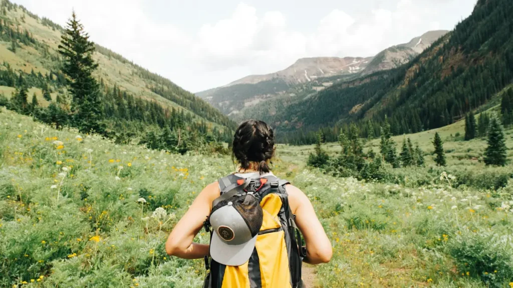 Randonneuse avec un sac à dos dans une vallée de montagne