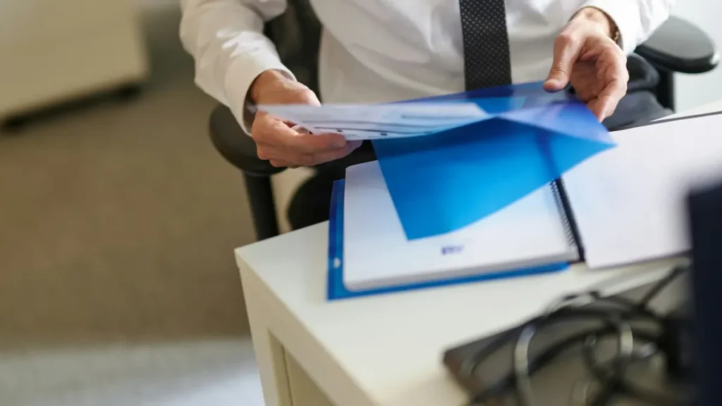 Personne qui sort des documents d'une pochette bleue