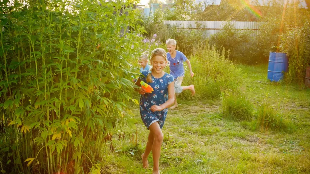 Enfants qui courent dans un pré au soleil