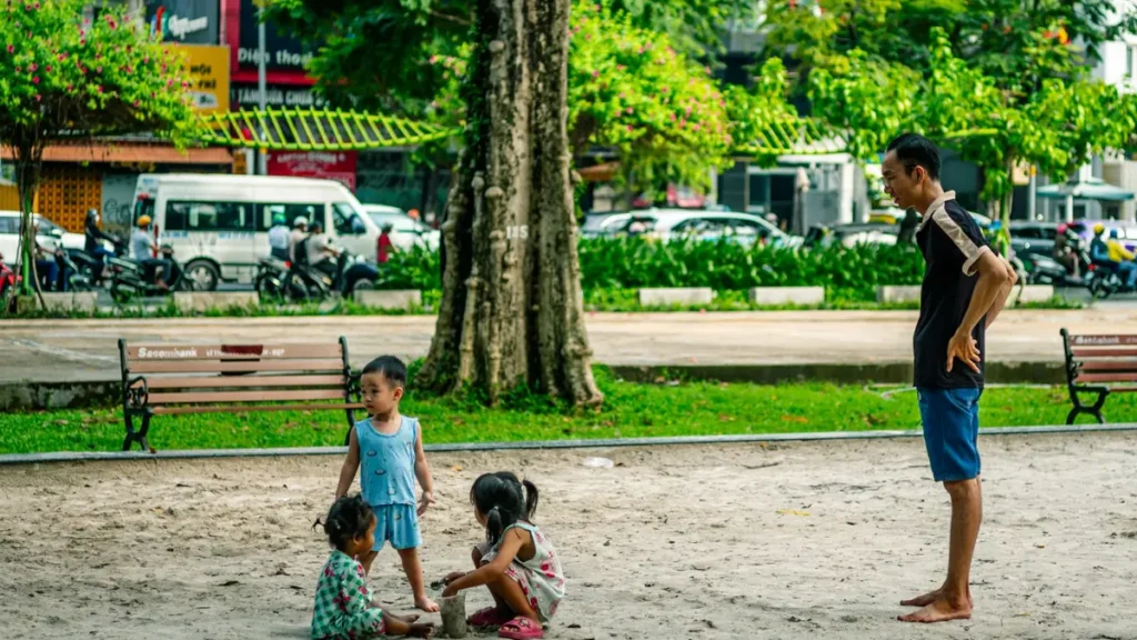 Adulte qui surveille des enfants qui jouent dans un parc