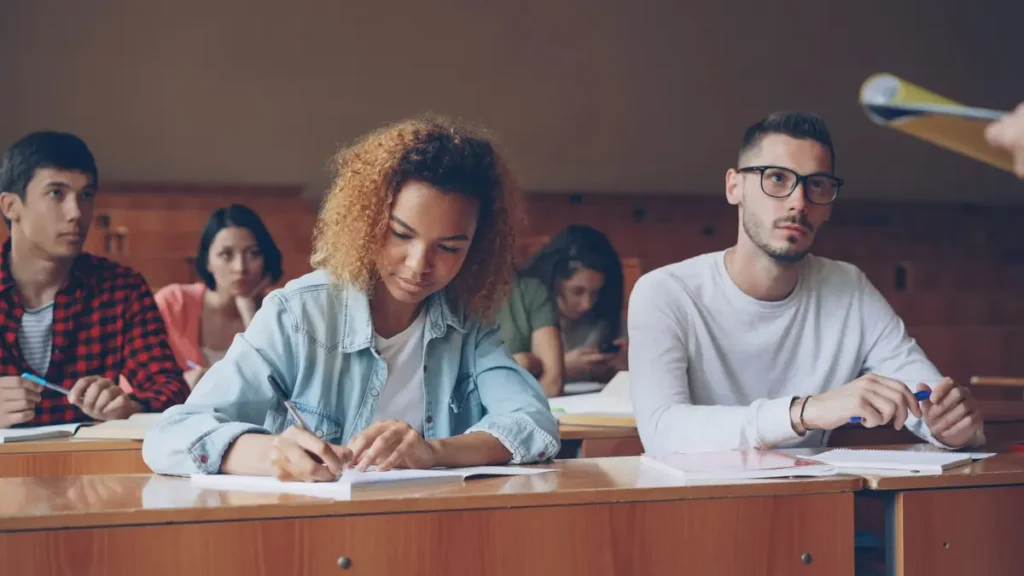 Étudiants qui passent un examen écrit dans un amphithéâtre