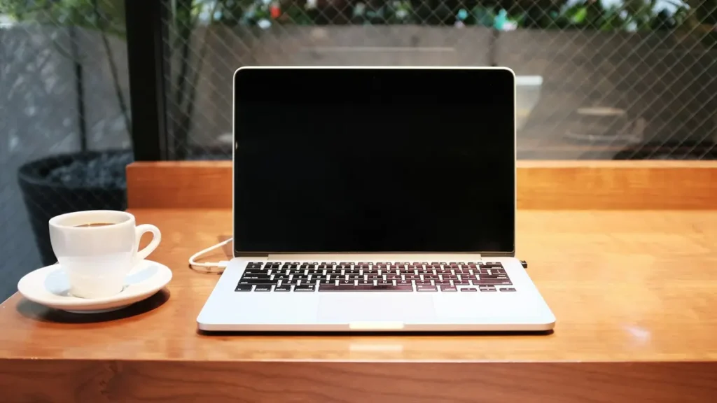 Ordinateur portable et tasse de café sur une table en terrasse