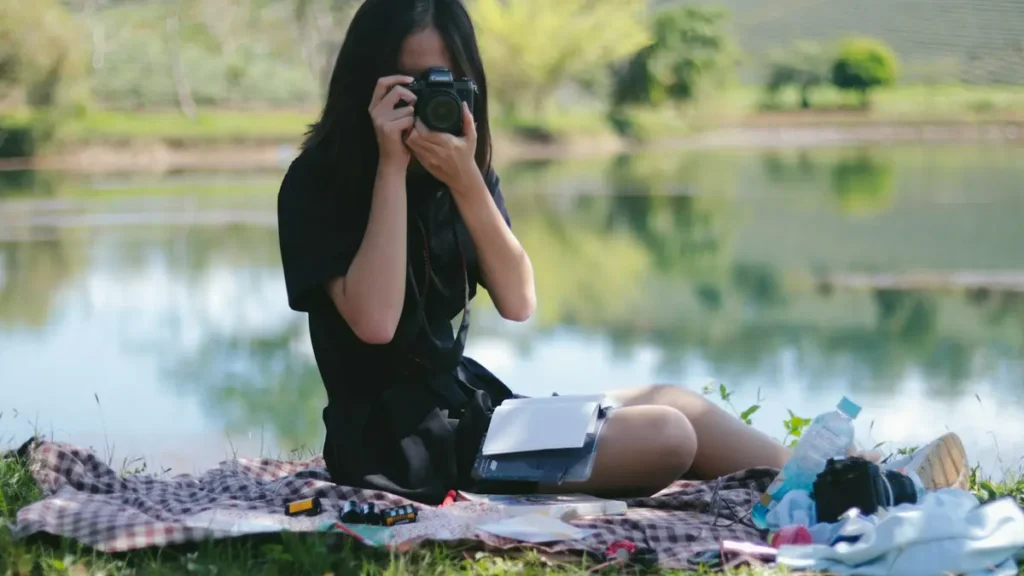 Jeune femme qui prend une photo au bord d'un lac