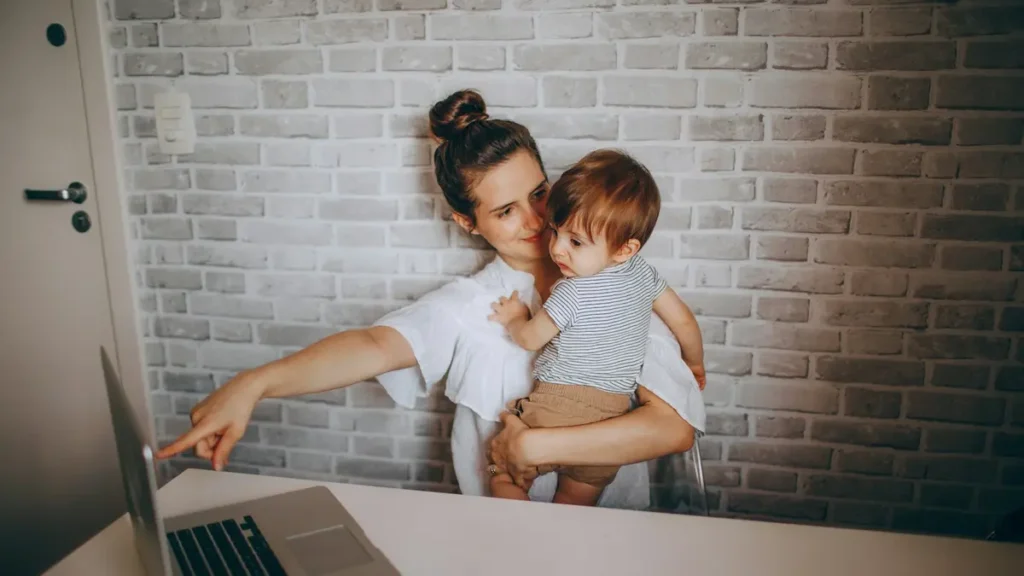 Mère tenant son bébé devant un ordinateur portable