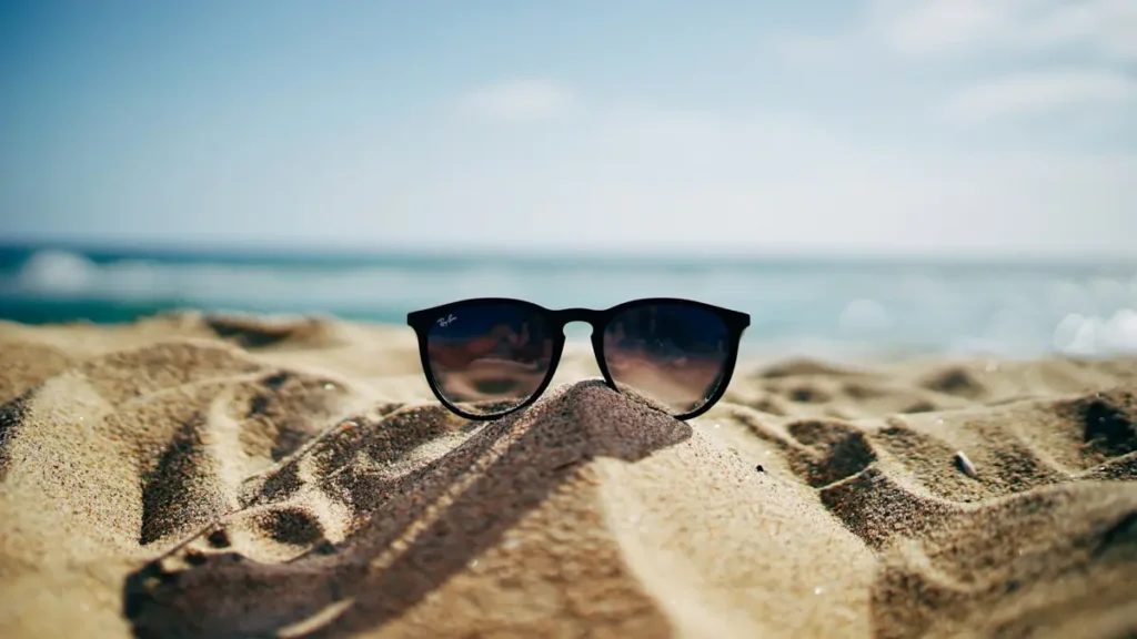 Lunettes de soleil posées sur le sable d'une plage