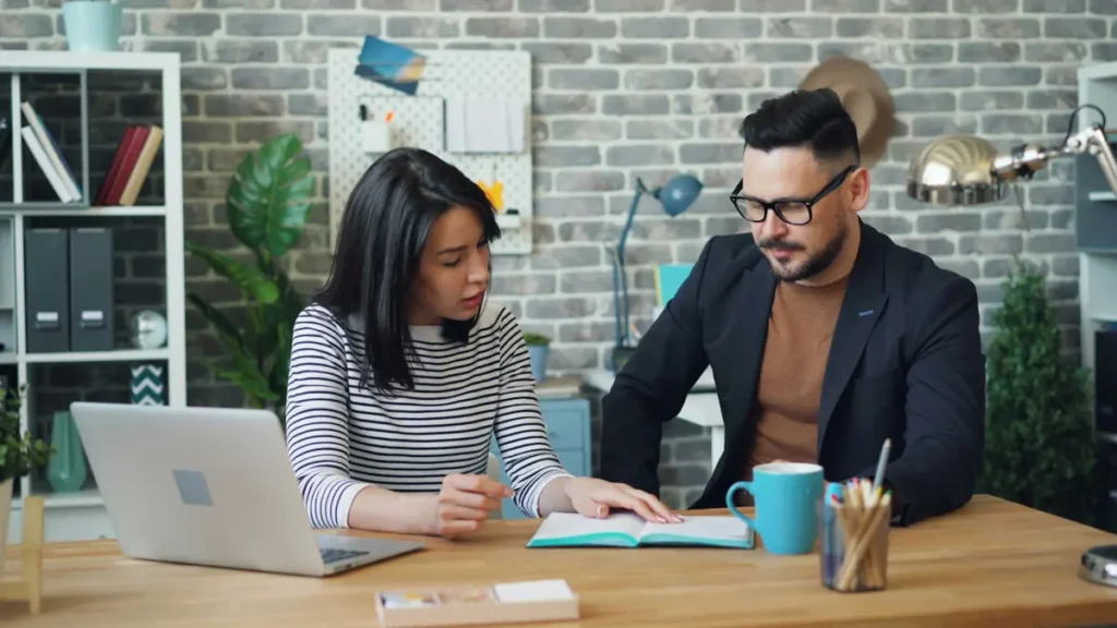 Conseiller qui échange avec une femme autour d'un bureau