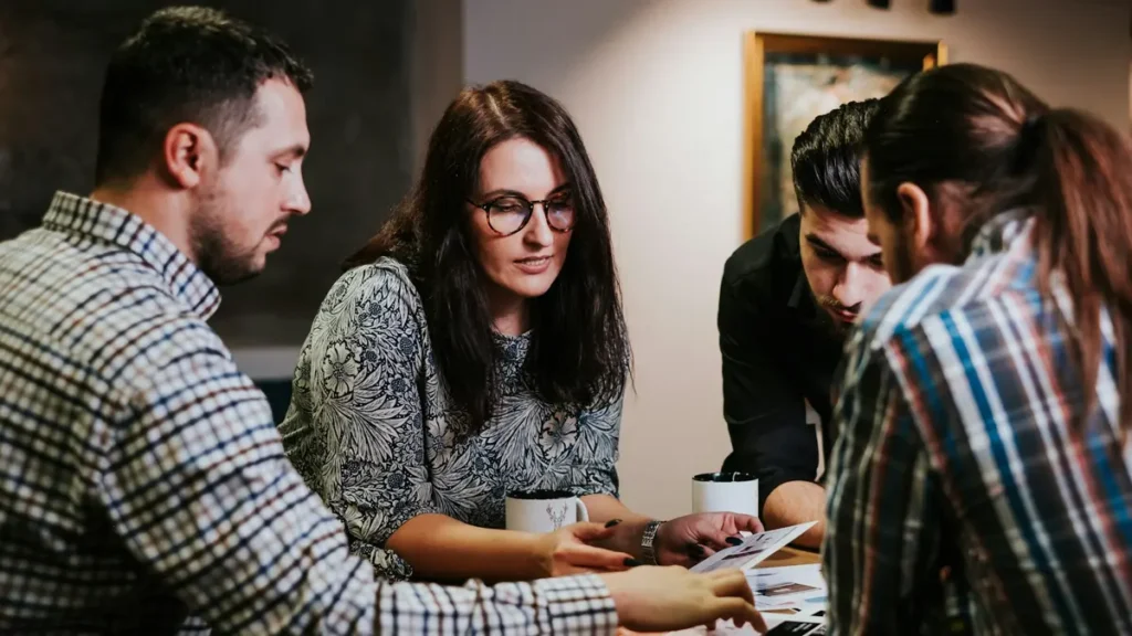 Quatre personnes qui étudient des documents autour d'une table
