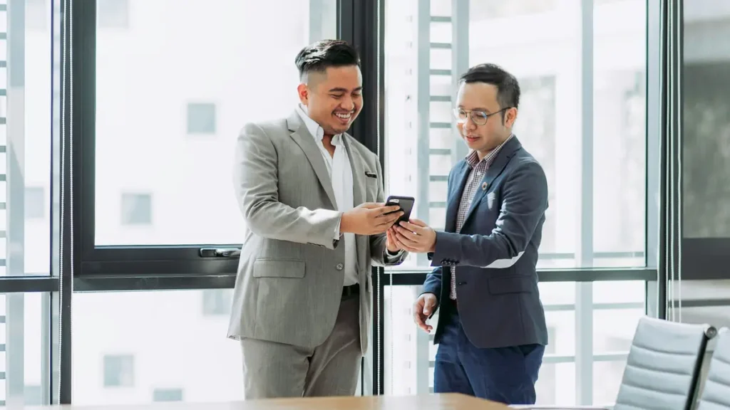 Deux hommes en costume qui échangent dans un bureau