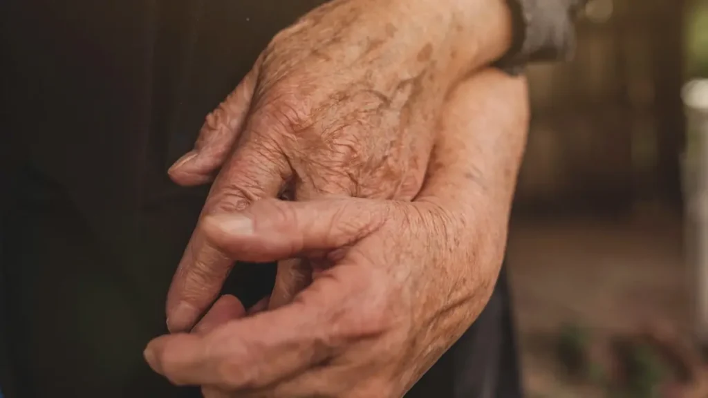 Mains d'une personne âgée tenues par une autre main