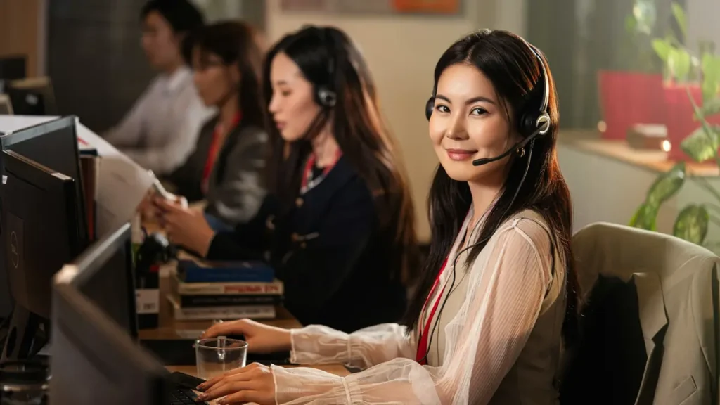 Assistante souriante avec un casque devant son ordinateur