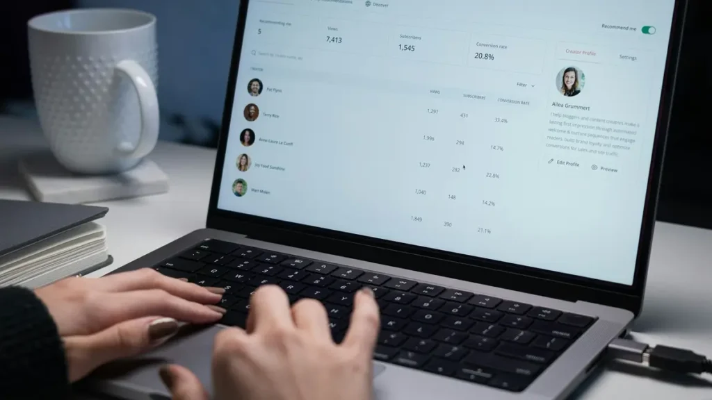 Mains sur le clavier d'un ordinateur affichant une liste de candidats