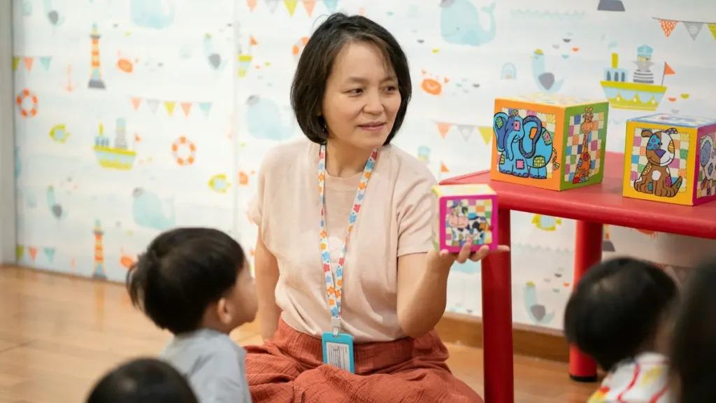 Éducatrice souriante assise avec de jeunes enfants dans une classe
