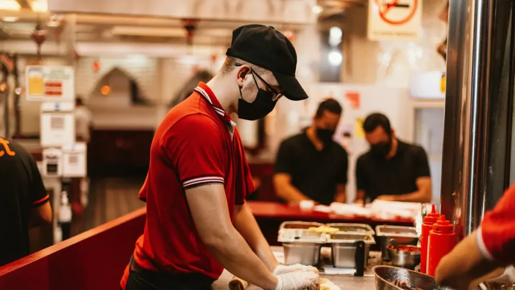 Équipier en tenue rouge qui prépare des plats en cuisine