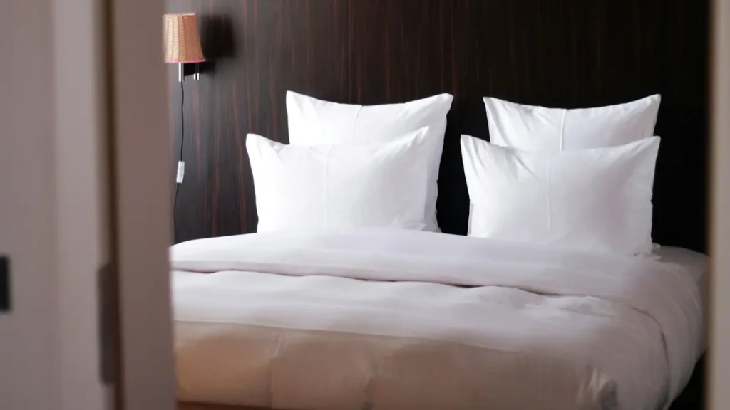Lit d'hôtel avec draps et oreillers blancs