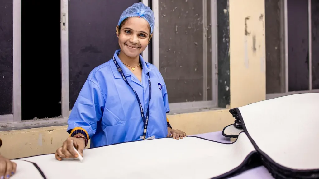 Infirmière souriante en tenue bleue dans un couloir d'hôpital