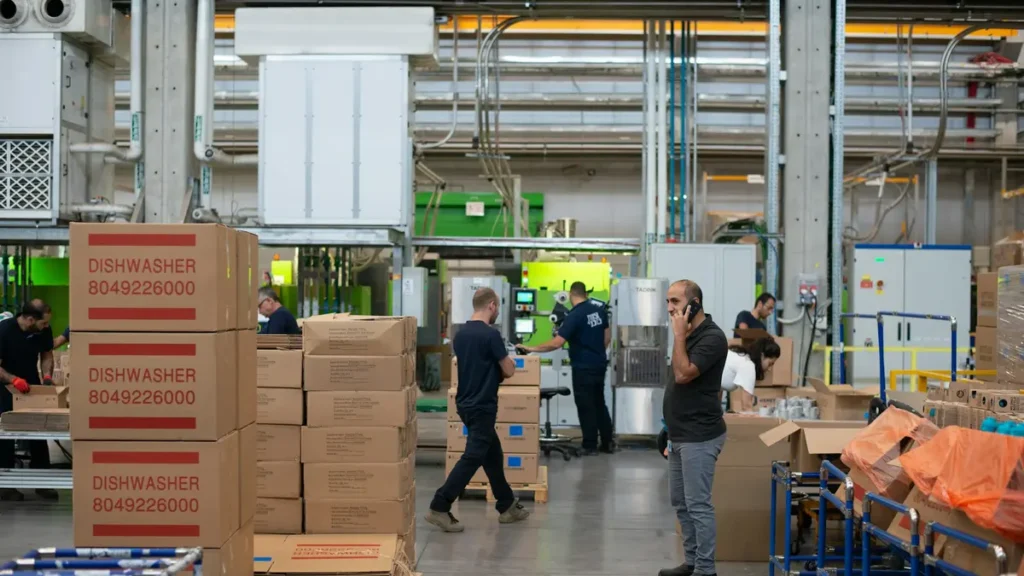 Entrepôt avec cartons empilés et employés