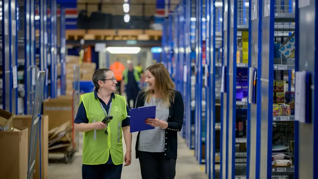 Deux employés de logistique dans une allée d'entrepôt
