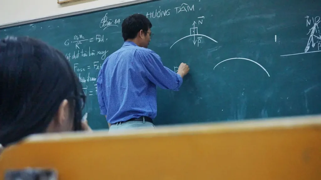 Enseignant qui écrit au tableau dans une salle de classe