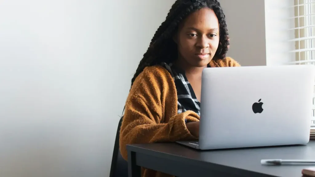 Jeune femme concentrée devant un ordinateur portable
