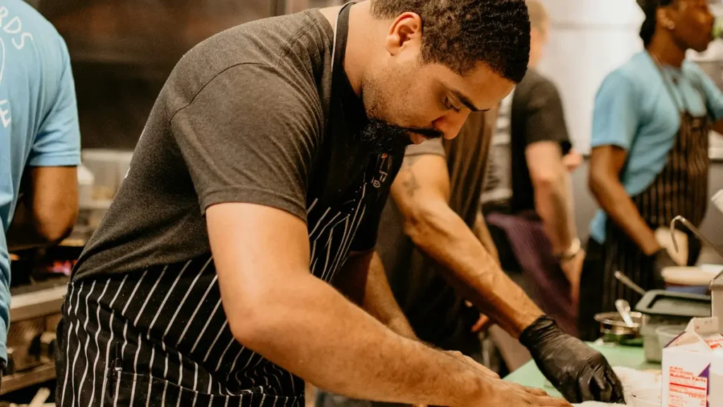 Cuisinier concentré au travail dans une cuisine animée