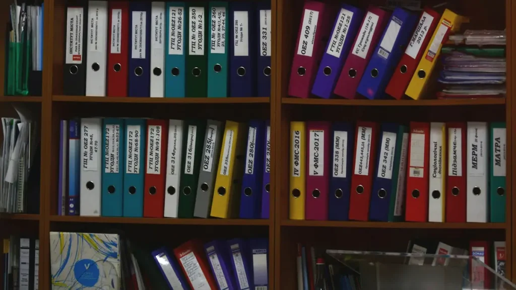 Classeurs de couleur rangés sur des étagères de bureau