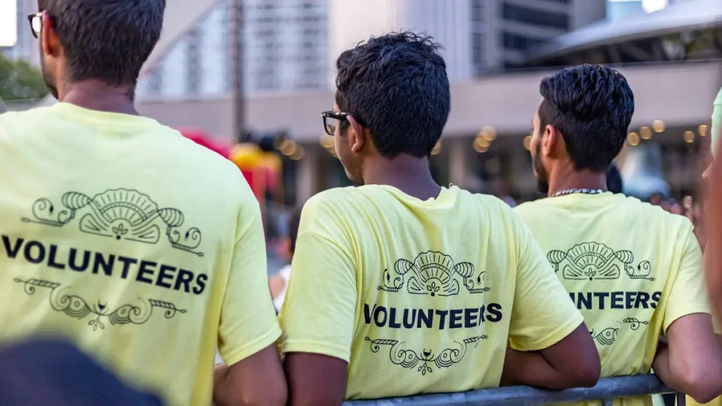Trois bénévoles en tee-shirts jaunes Volunteers