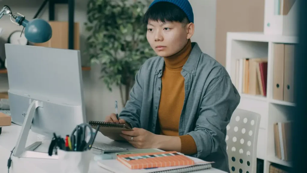 Étudiante qui travaille à un bureau devant un ordinateur