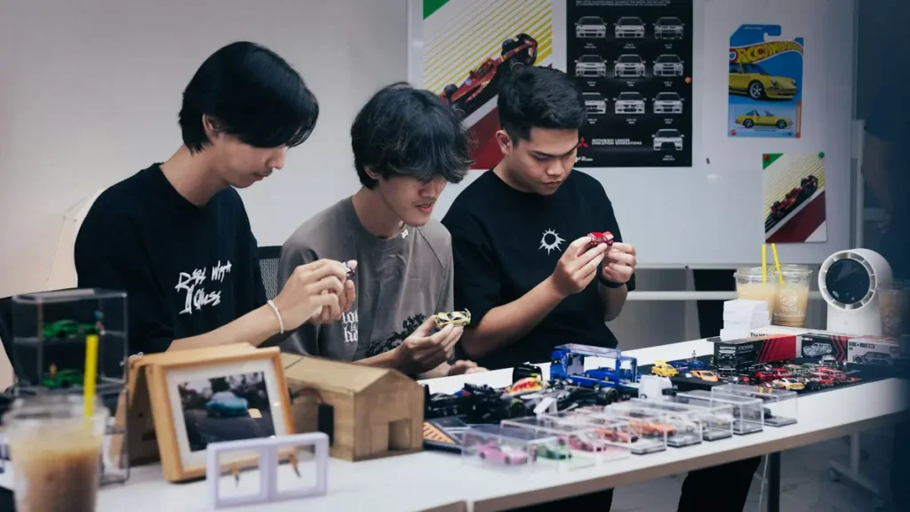 Trois jeunes qui assemblent des objets sur un établi