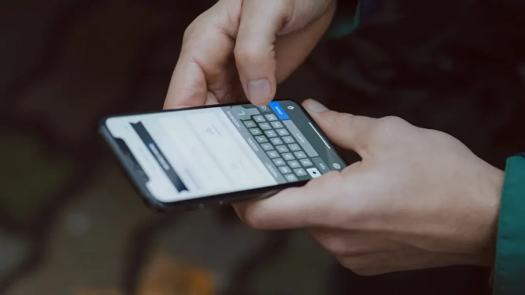 Mains qui tapent un message sur un smartphone