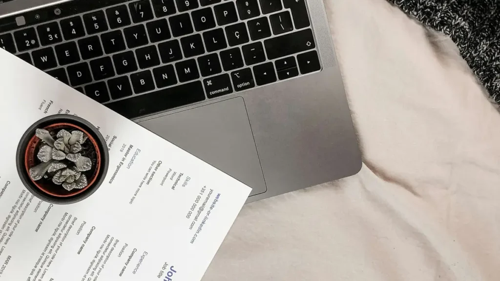 CV imprimé posé à côté d'un ordinateur portable