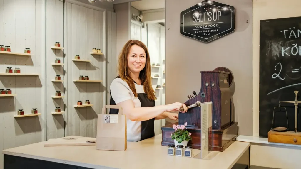 Vendeuse souriante derrière le comptoir d'une boutique
