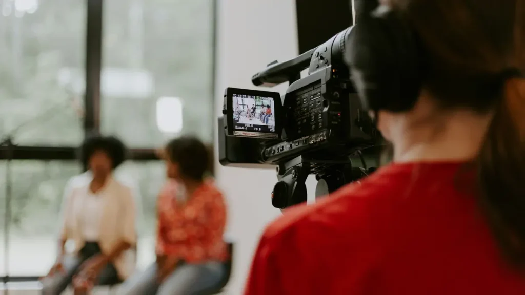 Caméra professionnelle filmant deux personnes en interview