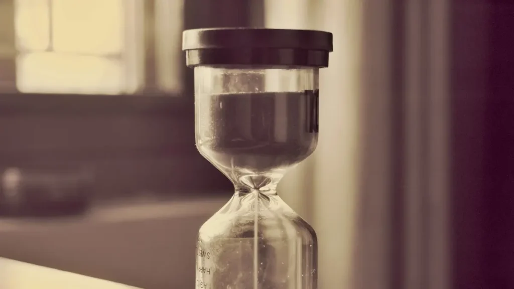 Sablier en verre près d'une fenêtre