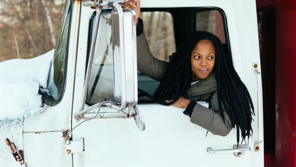Conductrice souriante à la fenêtre de la cabine d'un camion