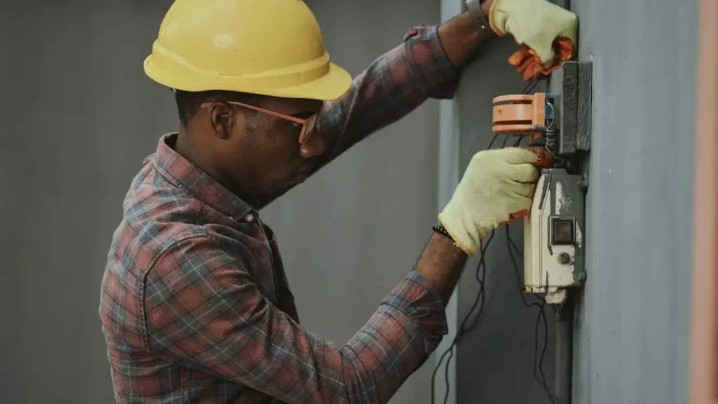 Électricien casqué qui intervient sur un compteur