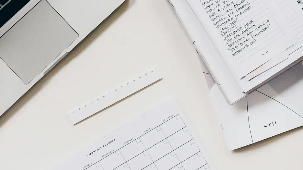 Ordinateur portable, carnet et documents sur un bureau blanc