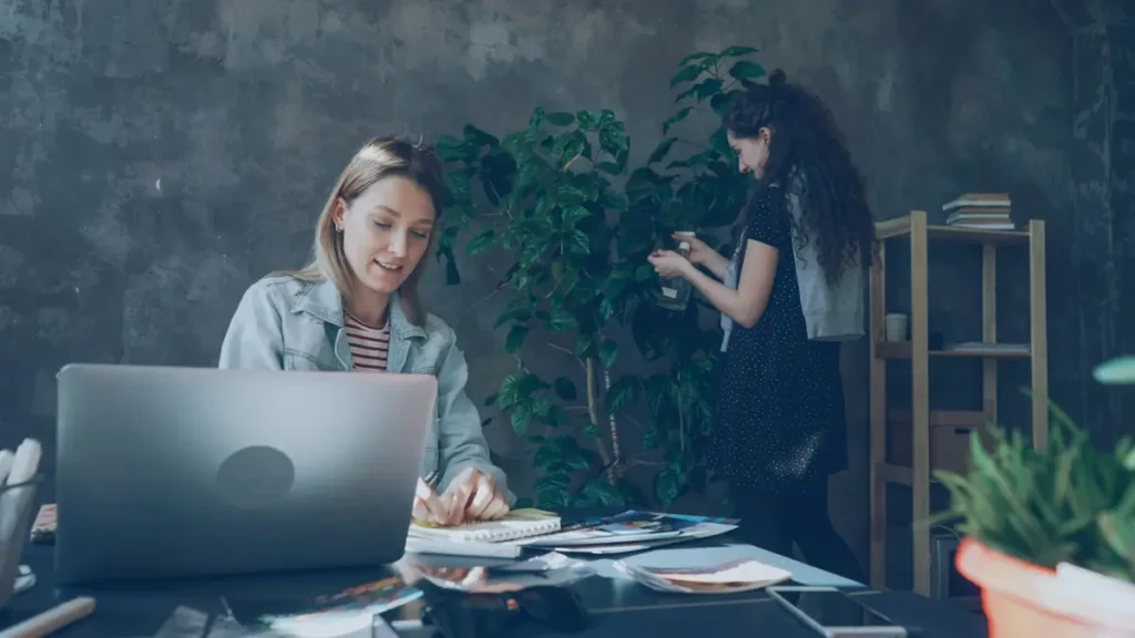 Deux femmes qui travaillent dans un bureau avec des plantes
