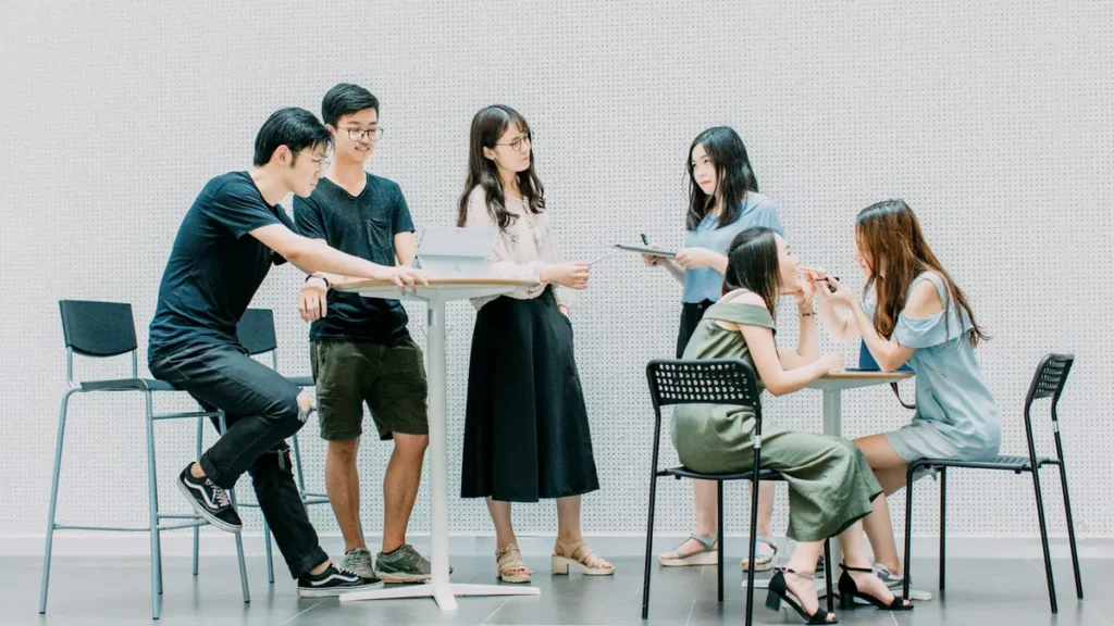 Groupe de jeunes professionnels qui échangent autour d'une table haute