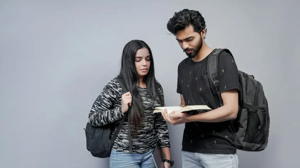 Deux étudiants qui consultent un document ensemble