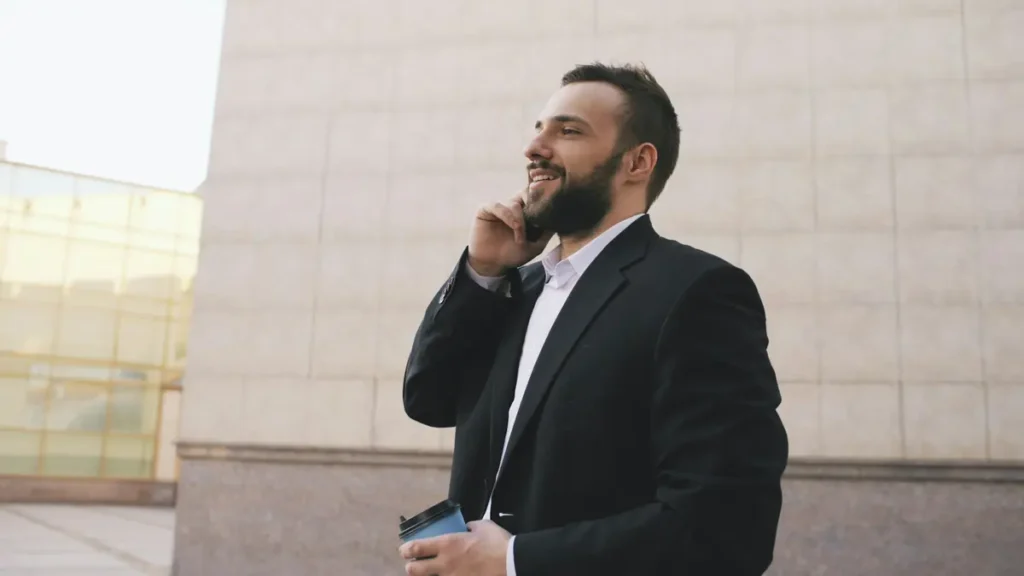 Homme en costume qui téléphone devant un bâtiment