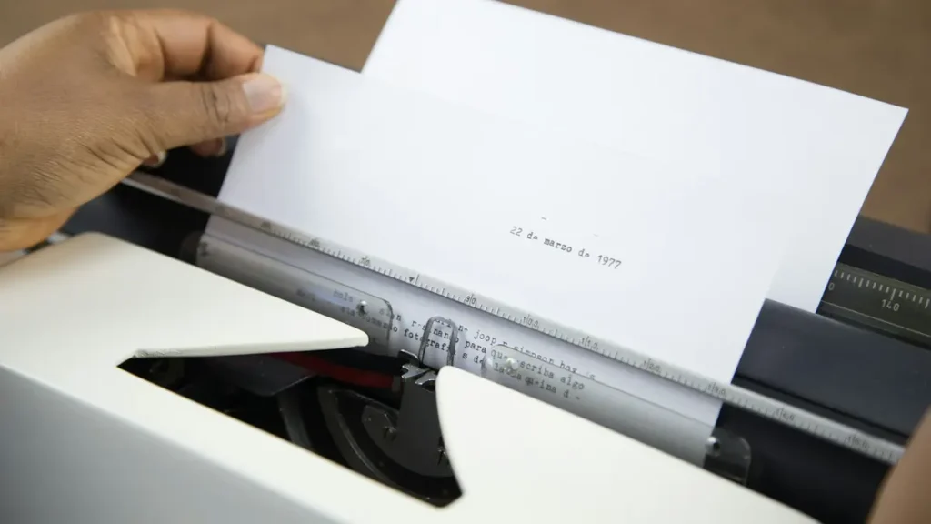 Main qui insère une feuille de papier dans une machine