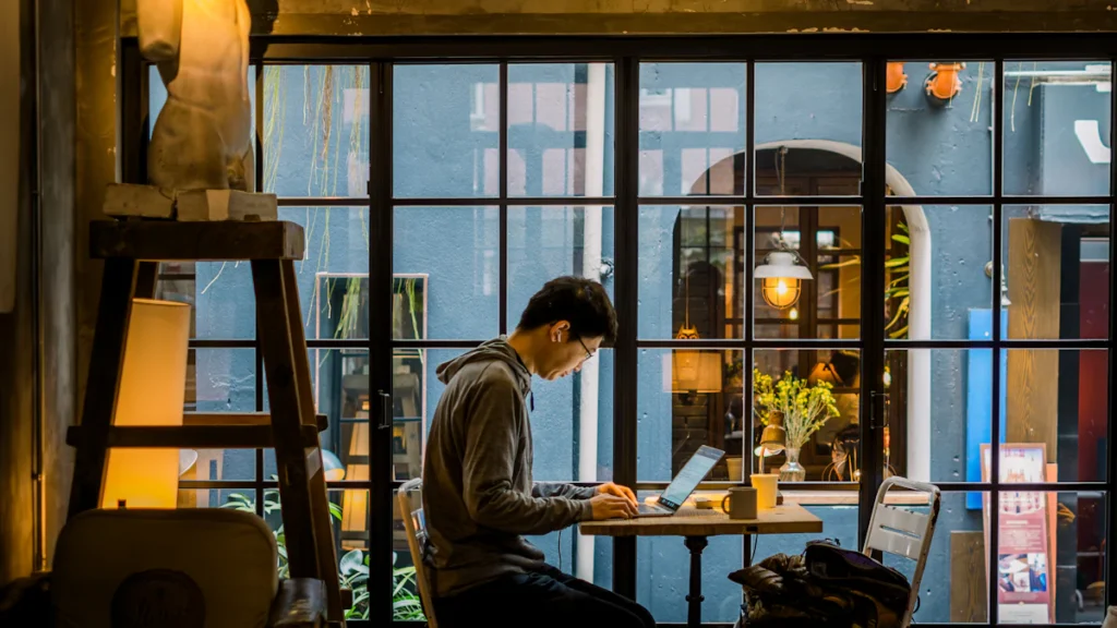 Personne qui travaille sur un ordinateur portable dans un café