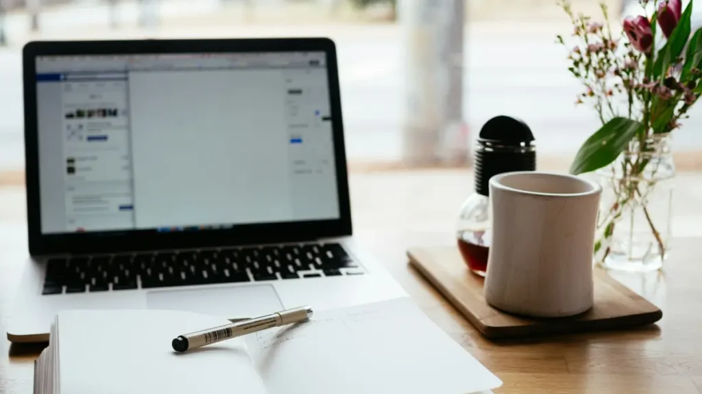 Ordinateur portable et carnet ouvert sur une table