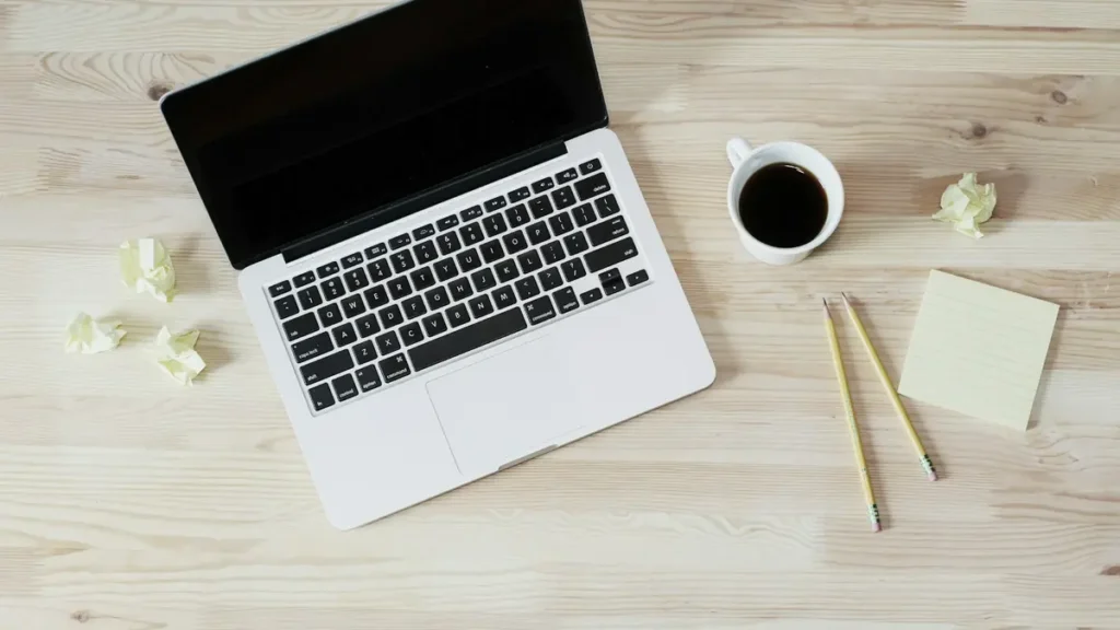 Ordinateur portable et tasse de café sur un bureau en bois