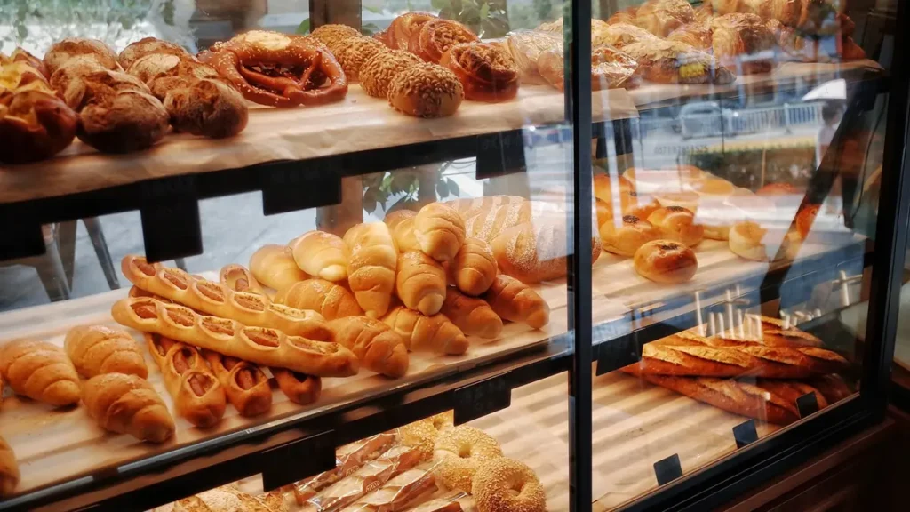 Vitrine de boulangerie remplie de viennoiseries et de baguettes