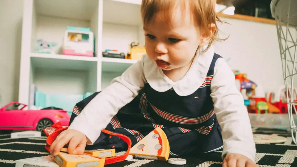 Jeune enfant qui joue avec des jouets sur un tapis
